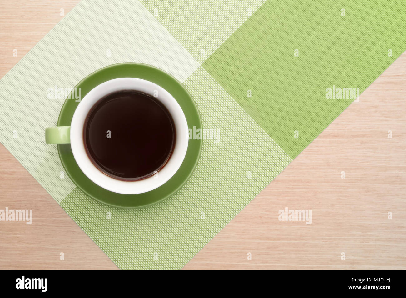 Grüne Tasse Kaffee auf dem Hintergrund der rosa Holz Tisch und Tischdecke. Ansicht von oben Stockfoto