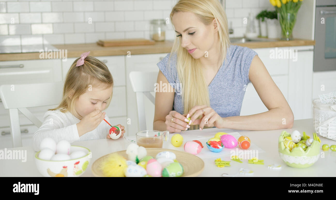 Mutter auf der Suche nach Mädchen färben Eier Stockfoto