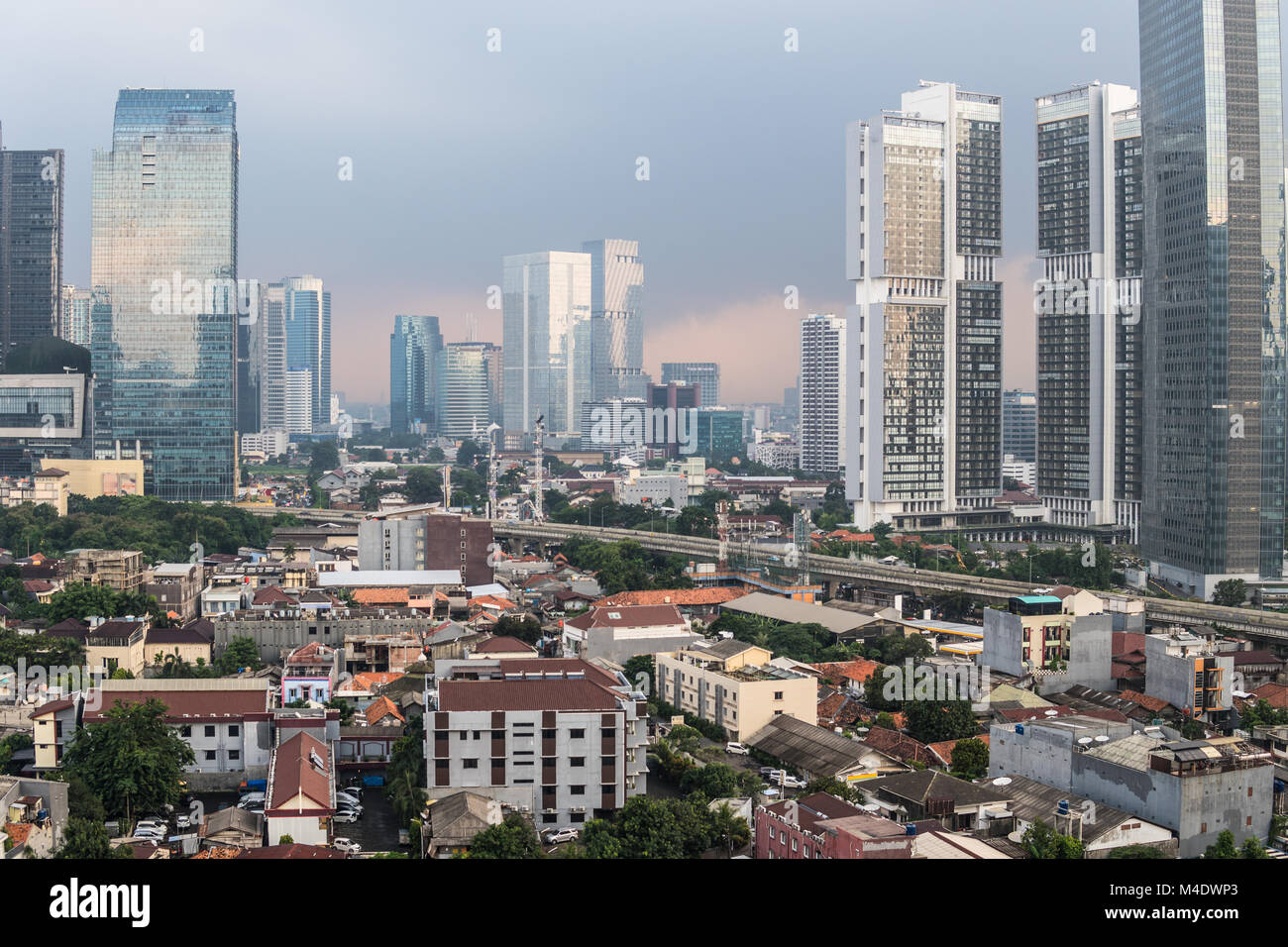 Luftaufnahme von einer Wohngegend im Herzen von Jakartas Geschäftsviertel mit modernen Wolkenkratzer und luxuriöse Eigentumswohnung Türme bei Sonnenuntergang in Indonesien Stockfoto
