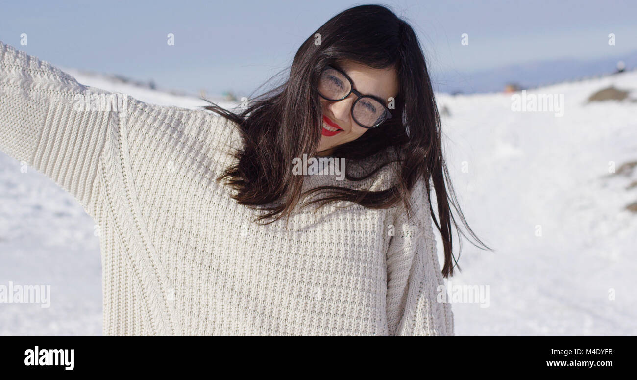 Glückliche junge Frau, die in der verschneiten Landschaft Stockfoto