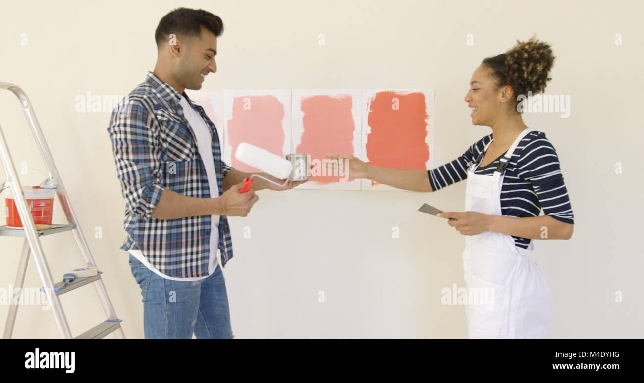 Lachende junge Paar Wählen einer Farbe Stockfoto