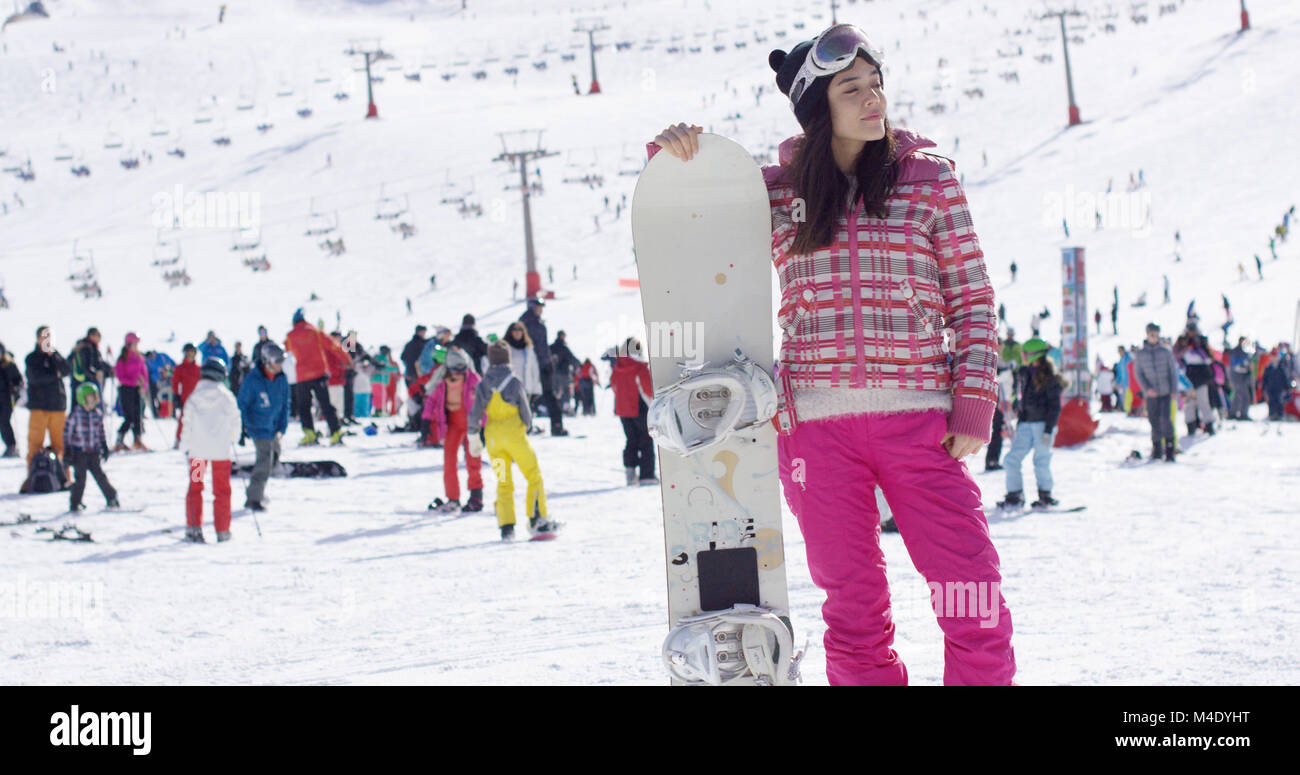 Junge Frau auf Skipiste mit Snowboard Stockfoto