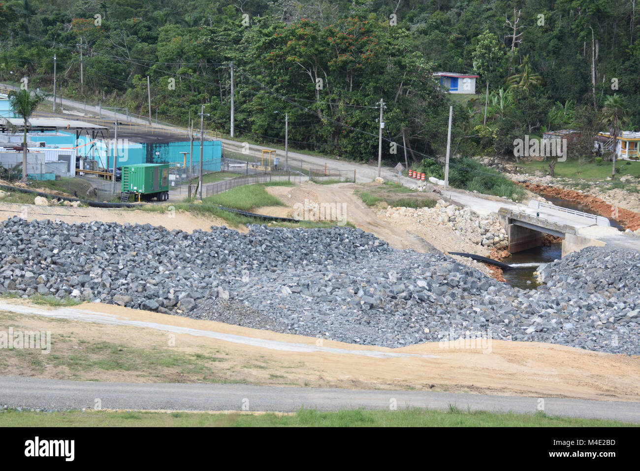 Site Übersicht Guajataca Dam, Puerto Rico, wo eine lokale Auftragnehmer der Brücke Ansatz repariert, so dass die U.S. Armee Korps der Ingenieure temporäre Power Team einen neuen Generator installieren könnte. Nach der ursprünglichen Generator ausgefallen und benötigte Ersatz, Auftragnehmer versucht, mehrere Routen zu versuchen und zu erhalten das neue installiert, aber sie waren nicht in der Lage, bis die provisorische Brücke Ansatz erstellt wurde. Stockfoto