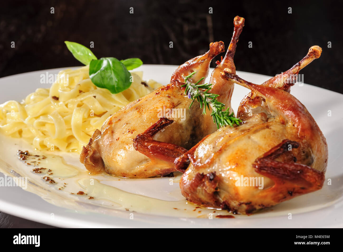 Geröstete oder gebratene Wachtel mit Kräutern und tagliatelle Stockfoto