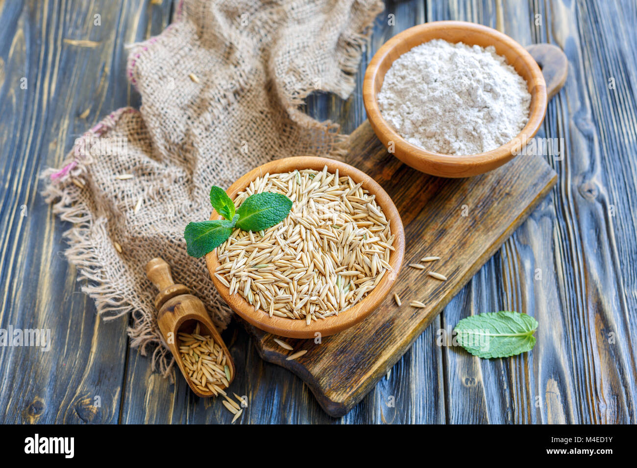 Hölzerne Schüsseln mit Haferflocken und Hafer. Stockfoto