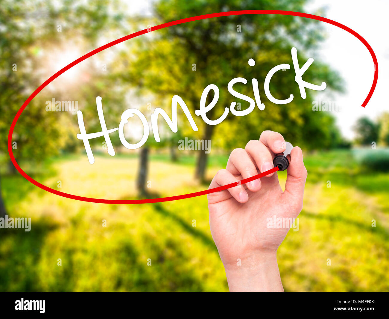 Mann Hand schreiben Heimweh mit schwarzem Marker auf visuelle Bildschirm Stockfoto