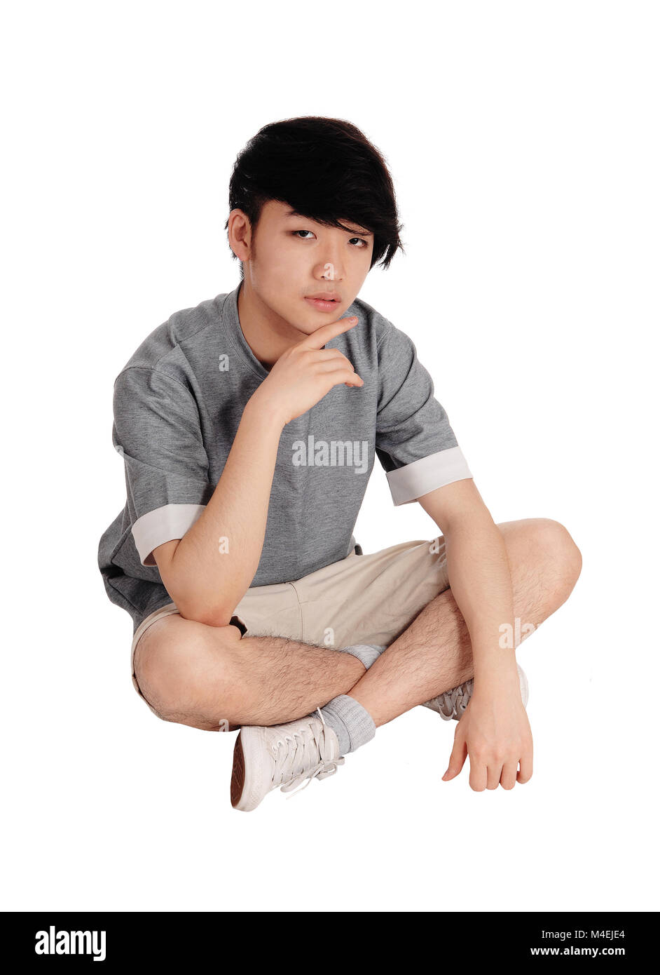 Jungen asiatischen Mann sitzt auf dem Boden. Stockfoto