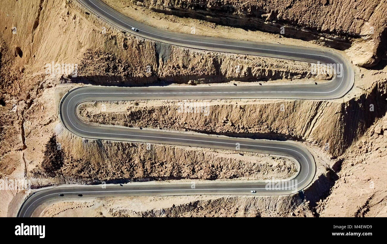 Wüste Straße - Luftbild von Datenverkehr, der eine Serpentine Mountain Road und nach unten Stockfoto