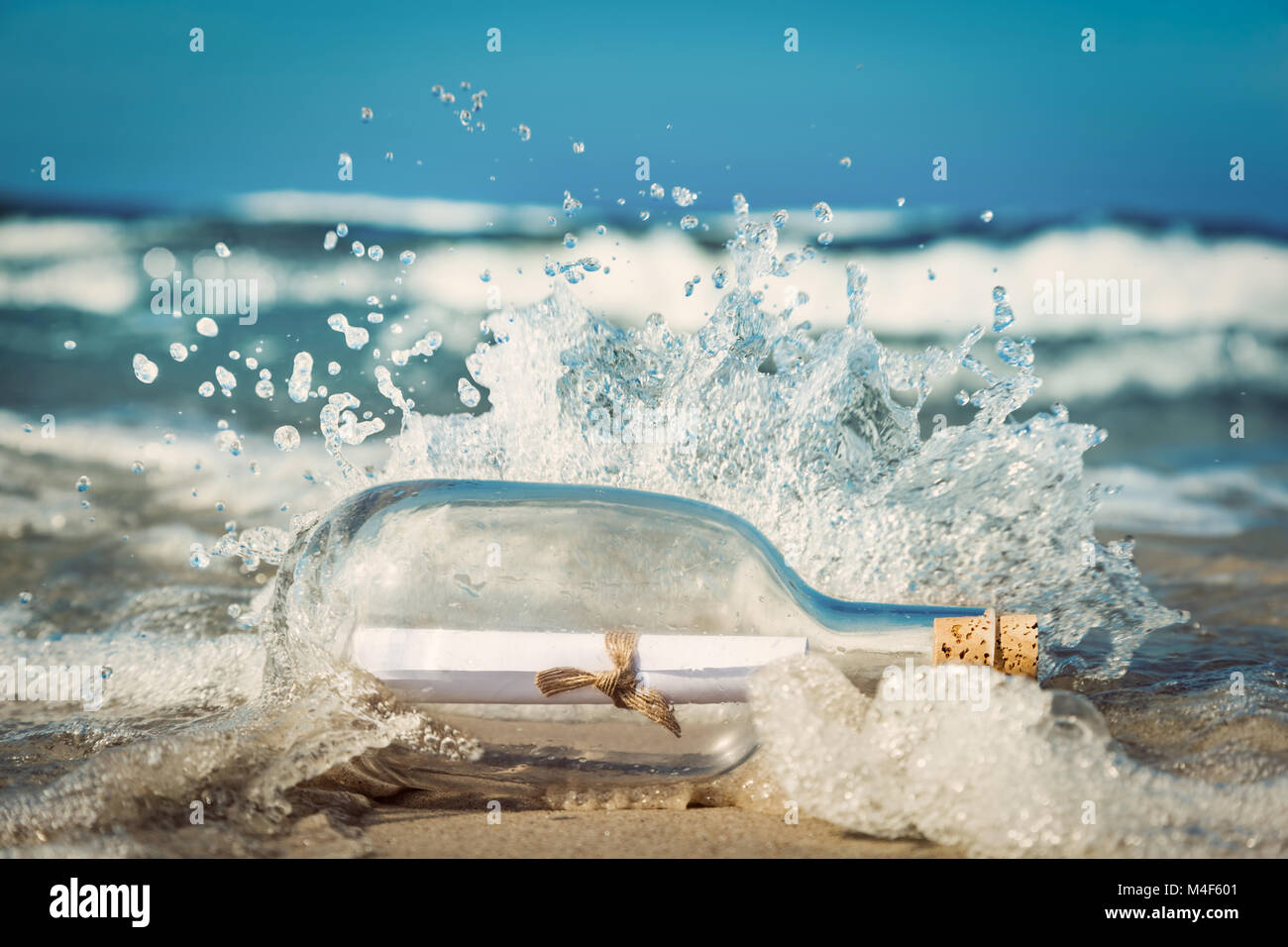 Nachricht in die Flasche kommen mit Welle aus dem Ozean Stockfoto