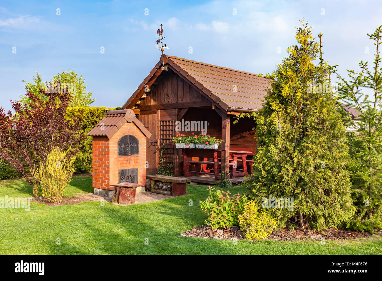 Angelegter Garten mit Grill und Holz Gartenhaus Stockfoto