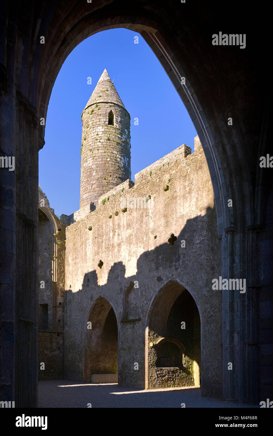 Runde Turm aus c. 1100 Schuß durch einen Bogen im Chor. Der Rock Of Cashel Klosteranlage, County Tipperary, Irland County Tipperary, Irela Stockfoto