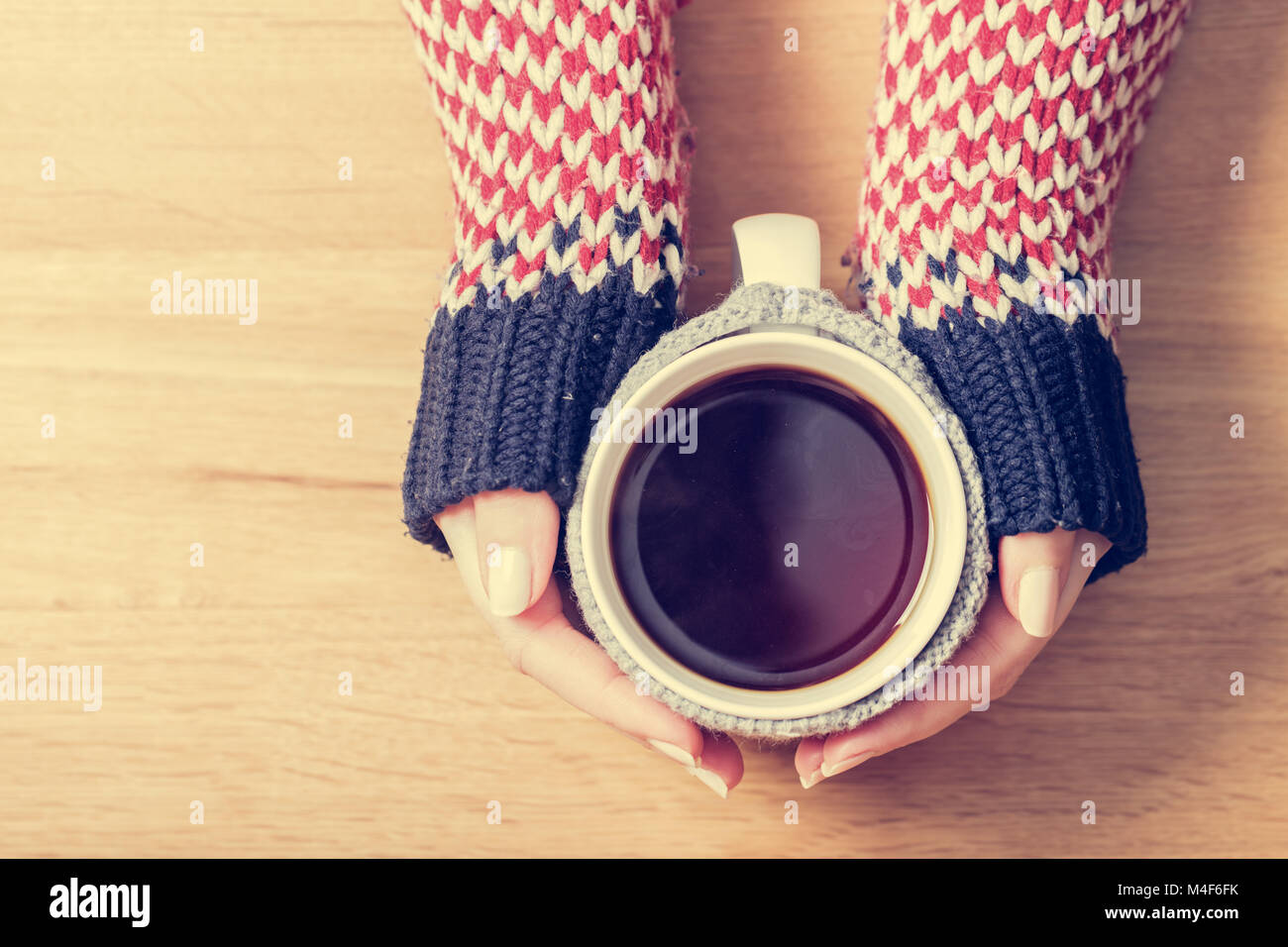 Heiße Tasse von Kaffee Erwärmung frau Hände im Retro-Jumper. Stockfoto