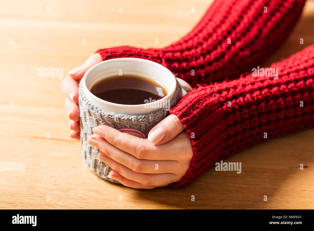Heiße Tasse von Kaffee Erwärmung frau Hände im Retro-Jumper. Stockfoto