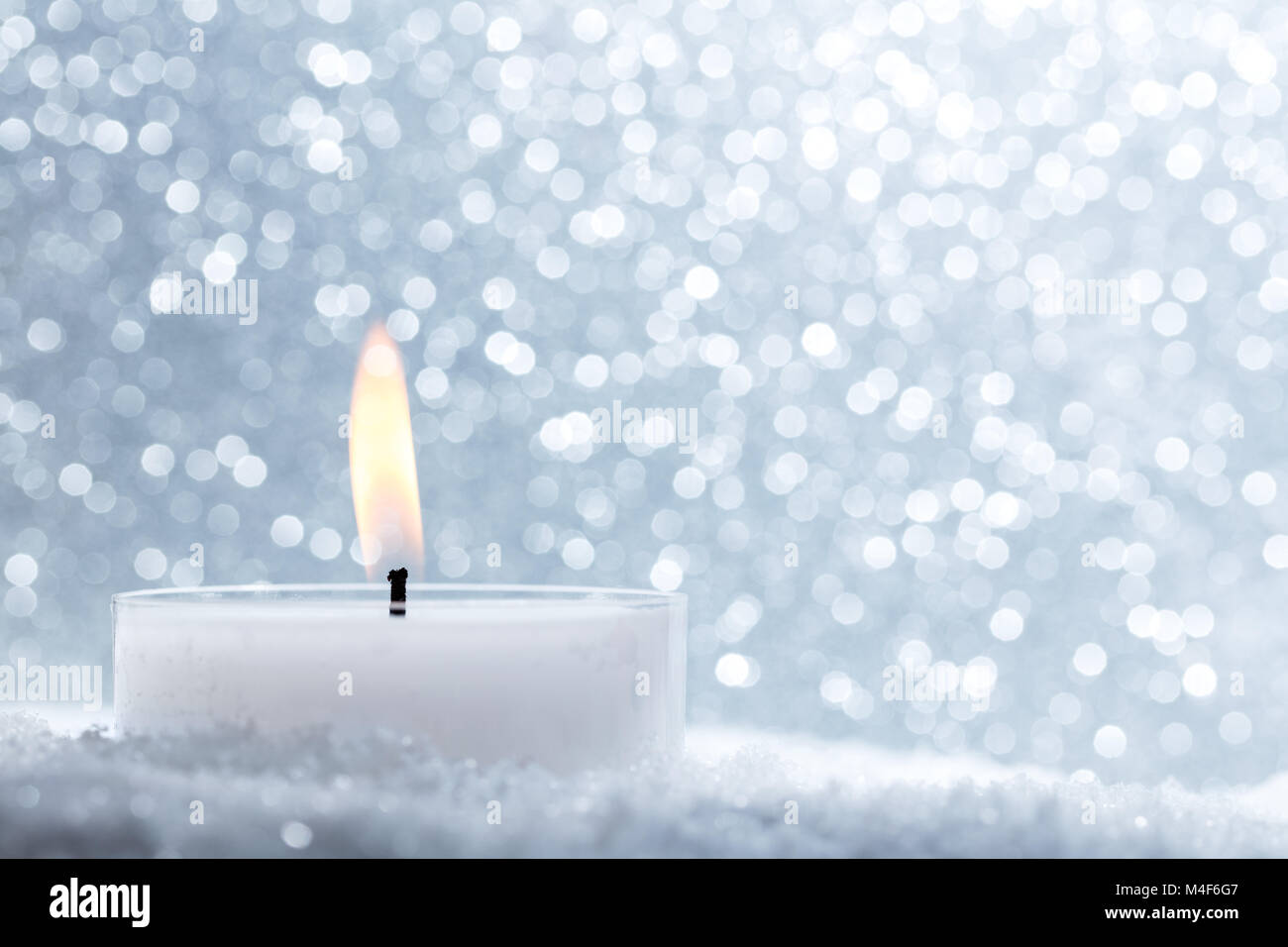 Chistmas Kerze glühende auf Glitzer Hintergrund. Stockfoto