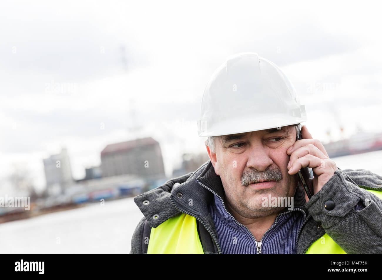 Senior Engineer Builder auf dem Telefon an der Baustelle. Stockfoto