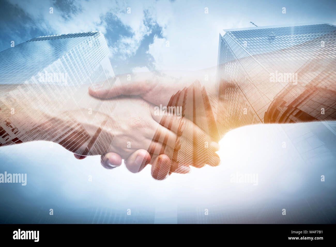 Business Handshake über moderne Wolkenkratzer, Double Exposure. Stockfoto