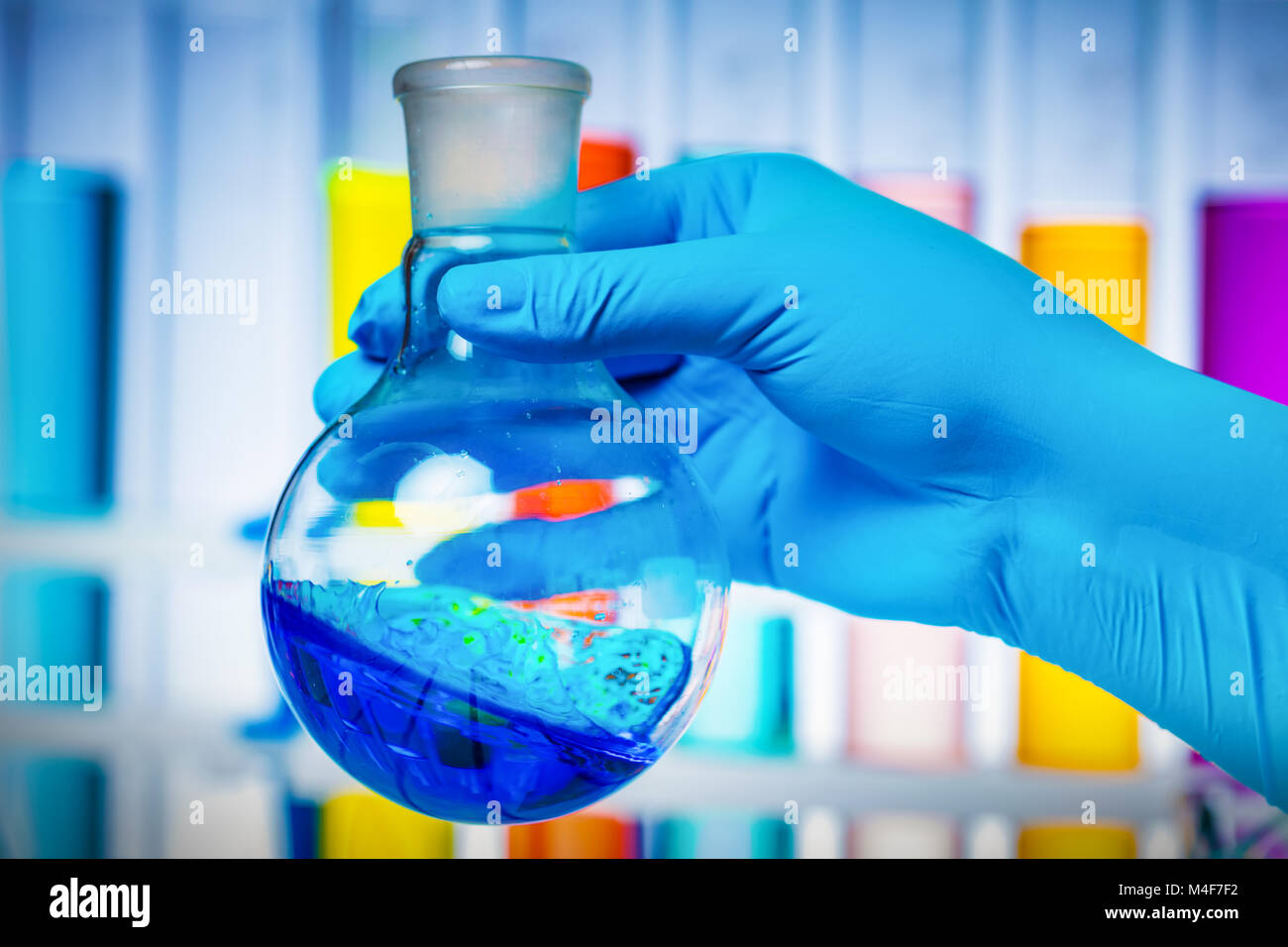 Die Wissenschaftler Hand mit einem Reagenzglas mit Flüssigkeit. Stockfoto