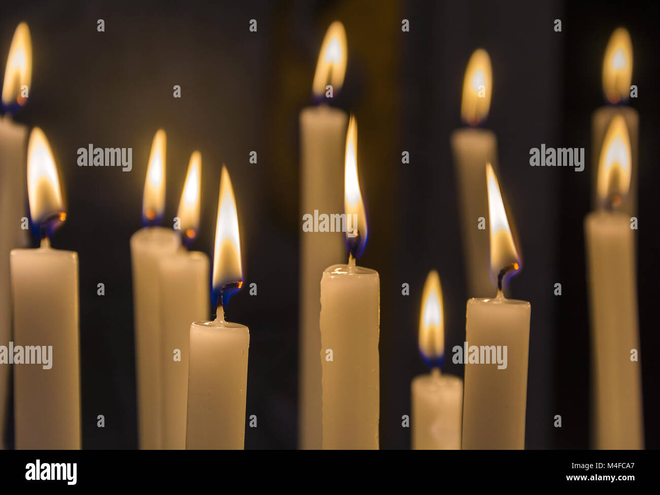 Brennende Kerzen in der katholischen Kirche auf dunklem Hintergrund closeup Bild Stockfoto