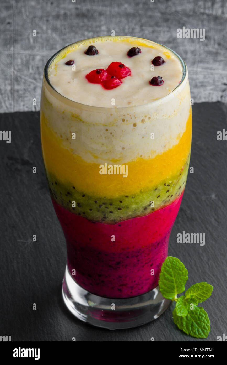 Bunte Smoothie aus verschiedenen Früchten schichtweise in ein Glas Stockfoto