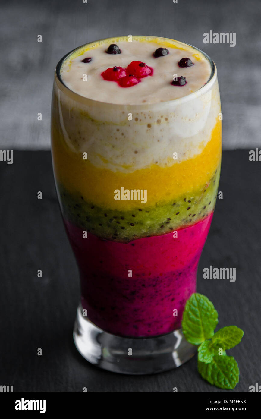 Bunte Smoothie aus verschiedenen Früchten schichtweise in ein Glas Stockfoto