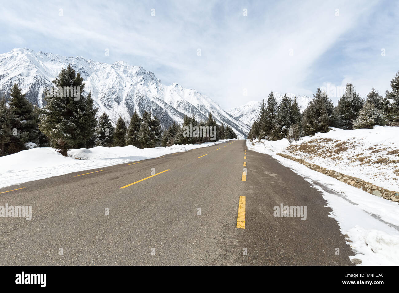 Leere asphaltierte Straße zwischen der schneebedeckte Berg Stockfoto