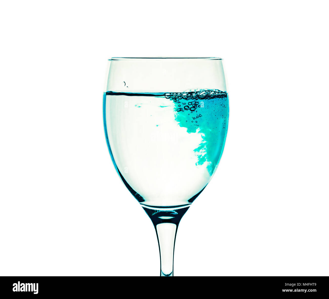 Ein Glas mit klarem Wasser ist mit blauen Flüssigkeit gefüllt  Stockfotografie - Alamy
