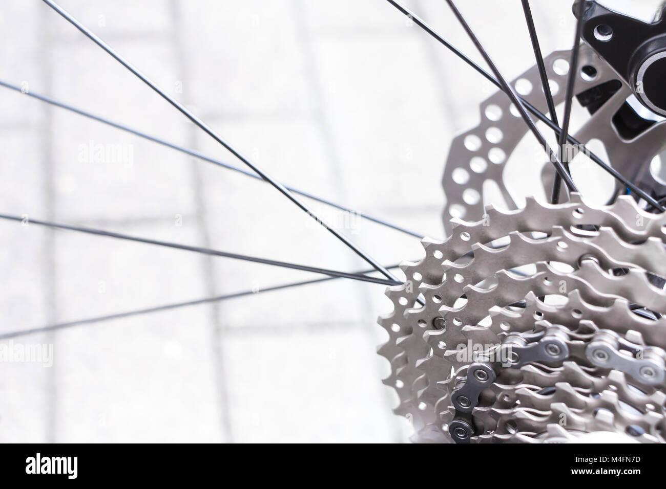 Fahrradausrüstung, Scheibenbremse und Metallkettenringe Detail, Nahaufnahme einer schwarzen hydraulischen Mountainbike Scheibenbremse im Hinterrad installiert. Stockfoto