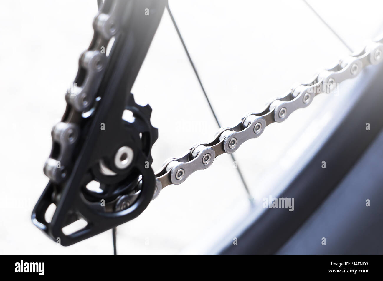 Fahrradrad und Getriebe Detail mit einer neuen sauberen Kette, Speichen und kleinen Kettenring des hinteren Mountainbike-Geschwindigkeitsschalters auf weißem Hintergrund Stockfoto