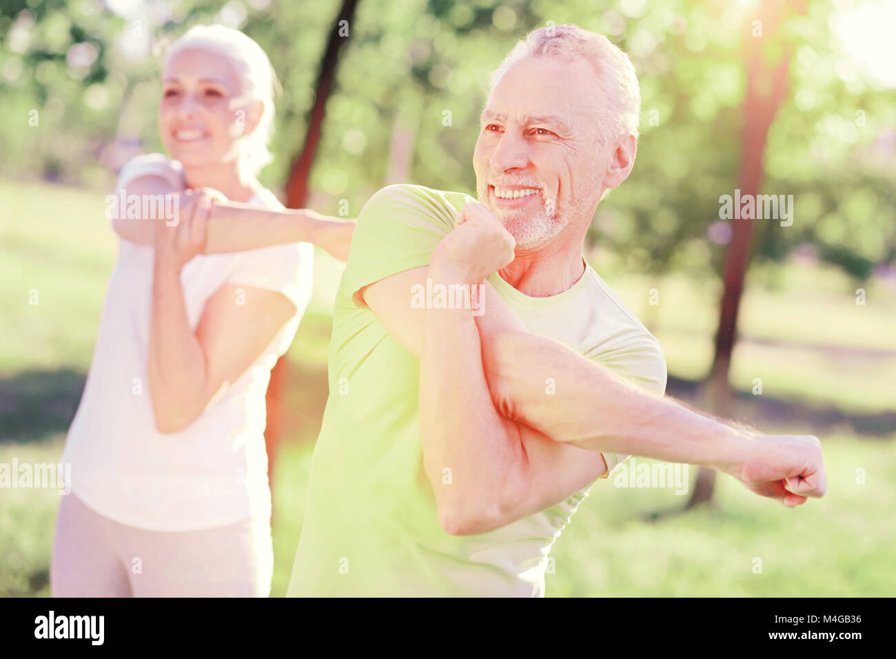 Ältere Familie stretching Arms im Freien Stockfoto