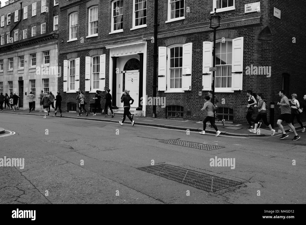Schwarz & Weiß Fotografie Büro in der Mittagspause Zeit hinter dem Royal Courts of Justice, London, England, UK ausführen Stockfoto
