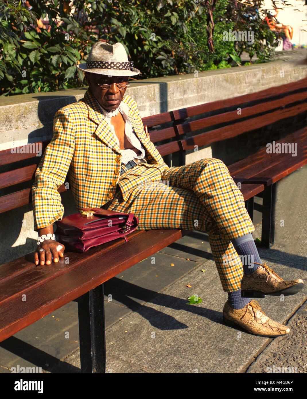 Farbe Foto von einem Mann mit trilby sitzen auf einer Bank in Marble Arch, London, England, UK. Credit: London Snapper Stockfoto