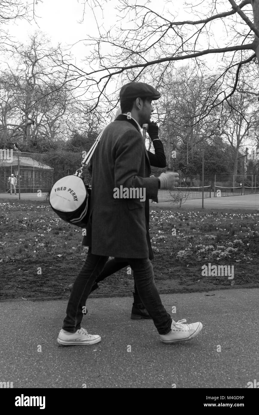Schwarz-weiß Foto eines Mannes mit einem Fred Perry Tasche in Lincoln's Inn Fields, Holborn, London, England, UK. Credit: London Snapper Stockfoto
