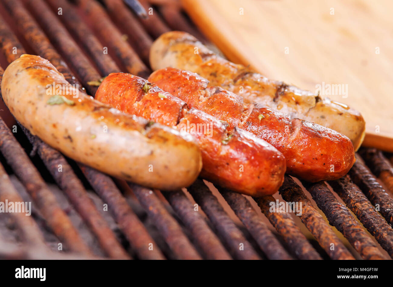 Nahaufnahme von drei grillen Würstchen am Grill zubereitet. Grillplatz