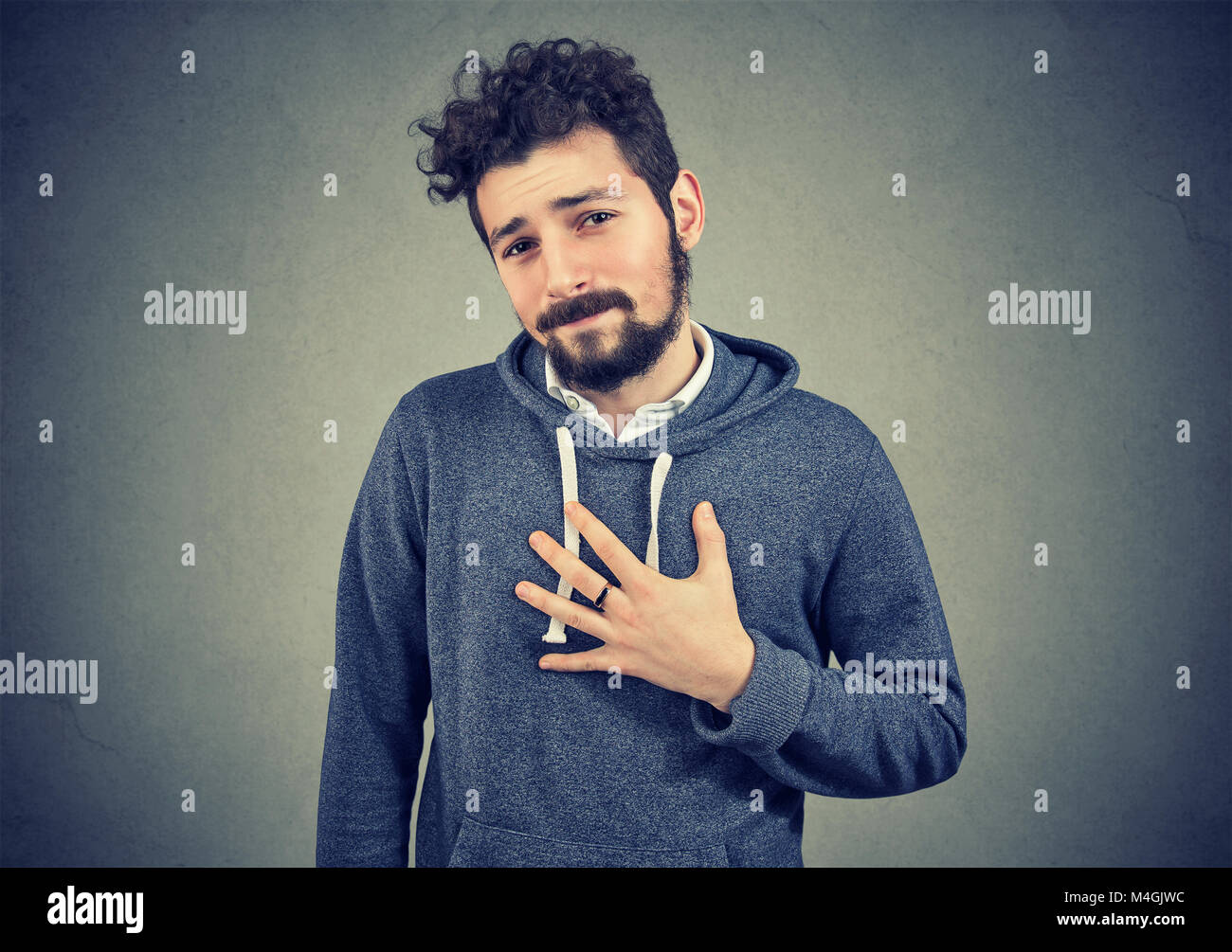 Junger Mann fragt ihn zu entschuldigen suchen mit Bedauern an der Kamera. Stockfoto