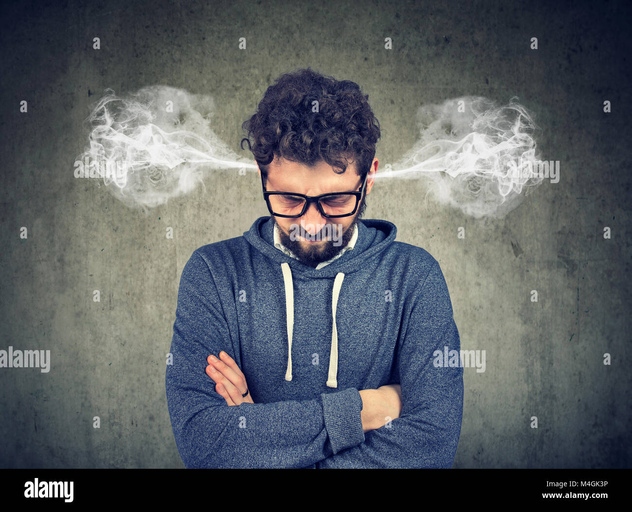 Zornigen jungen Mann, Blasen Dampf aus den Ohren, zu Nervenzusammenbruch auf grauem Hintergrund isoliert haben. Negative menschliche Emotionen Gesicht expressio Stockfoto