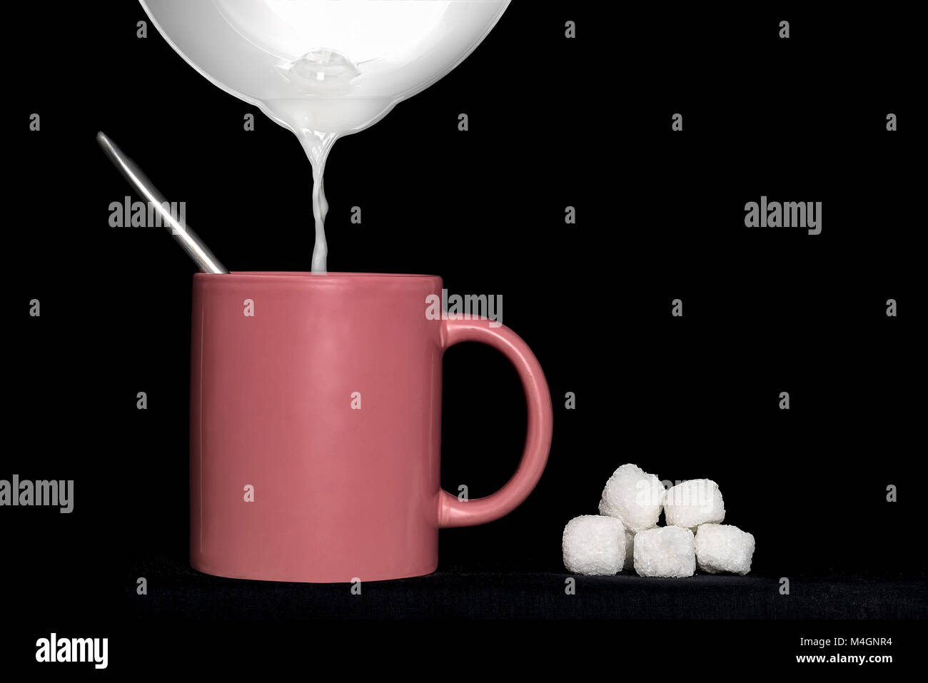 Milch Krug gefüllt eine Rose Schale mit weißen Würfel Zucker auf schwarzem Hintergrund Stockfoto