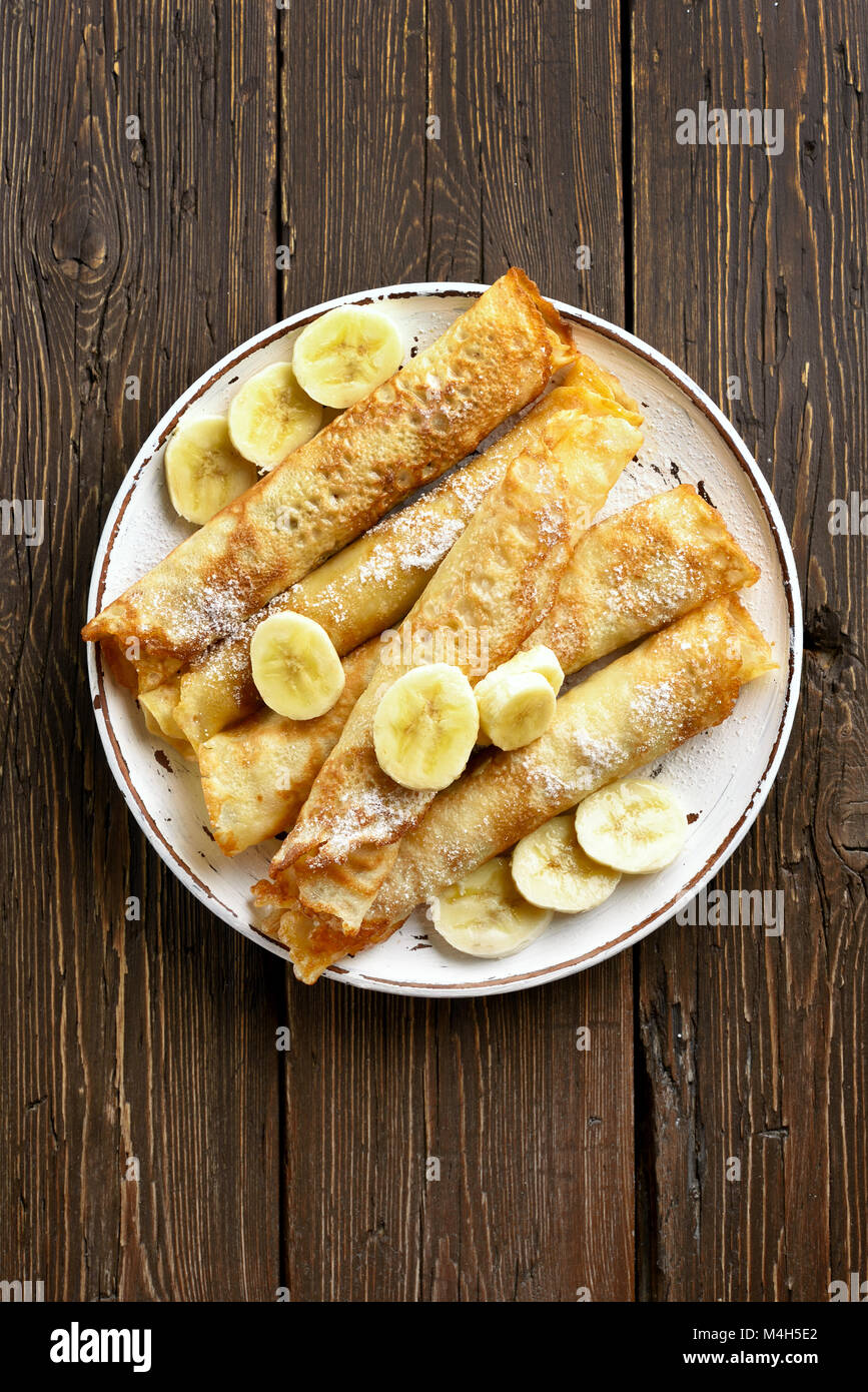 Dünne Pfannkuchen, Crepes Rolle mit bananenscheiben auf hölzernen Hintergrund mit kopieren. Ansicht von oben, flach Stockfoto