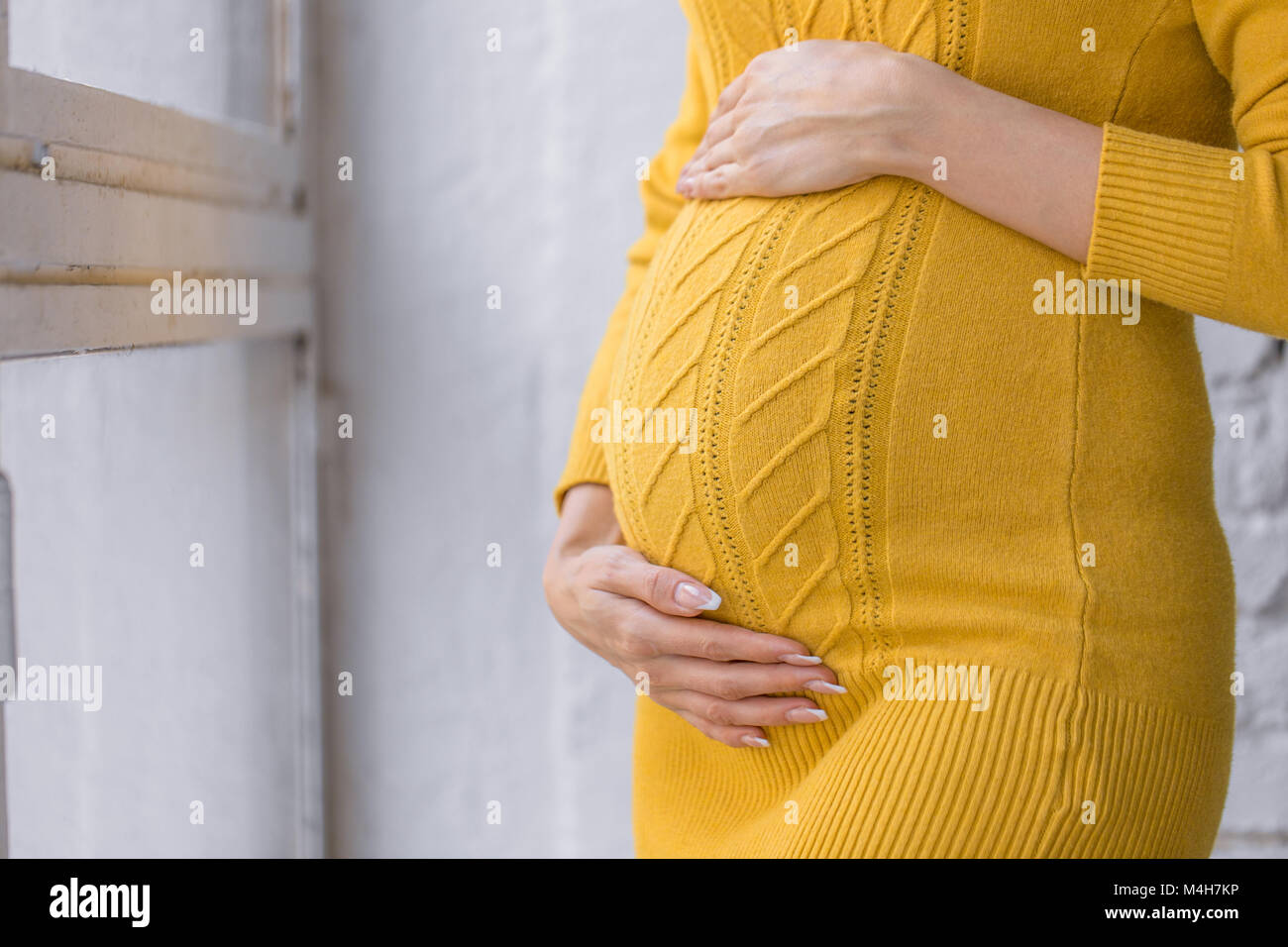Schwangerschaft, Mutterschaft, Erwartung Konzept - Nahaufnahme der Glückliche schwangere Frau mit großen Bauch im Fenster Stockfoto