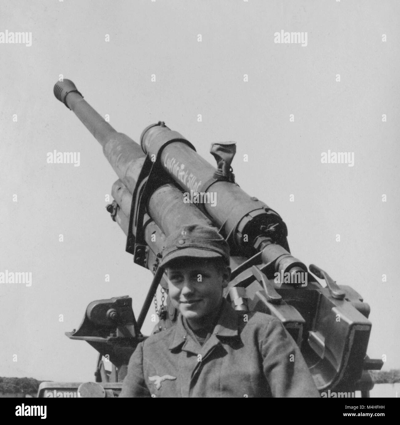 Eine junge Flak Artillerie Hilfsmittel in der Position eines Flak Batterie in Germering. Im Hintergrund der Russischen 8,5cm Flak 1939. Stockfoto