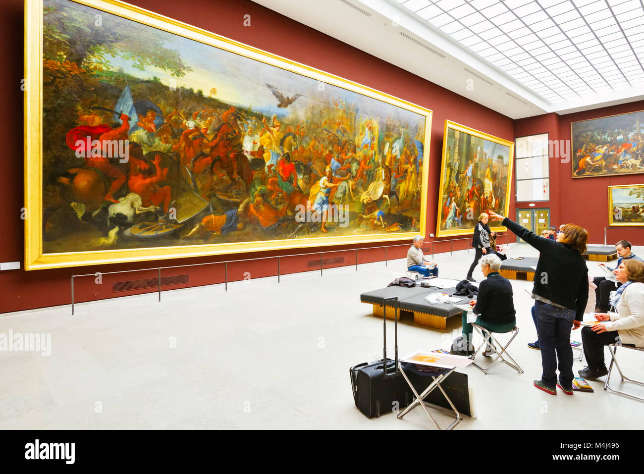 Frankreich, Paris, Louvre Museum. Eine Lehrerin führt eine Art Klasse unter der Renaissance gestaltete Kunstwerke. Dieser Riese Malerei fast deckt die Wand. Stockfoto