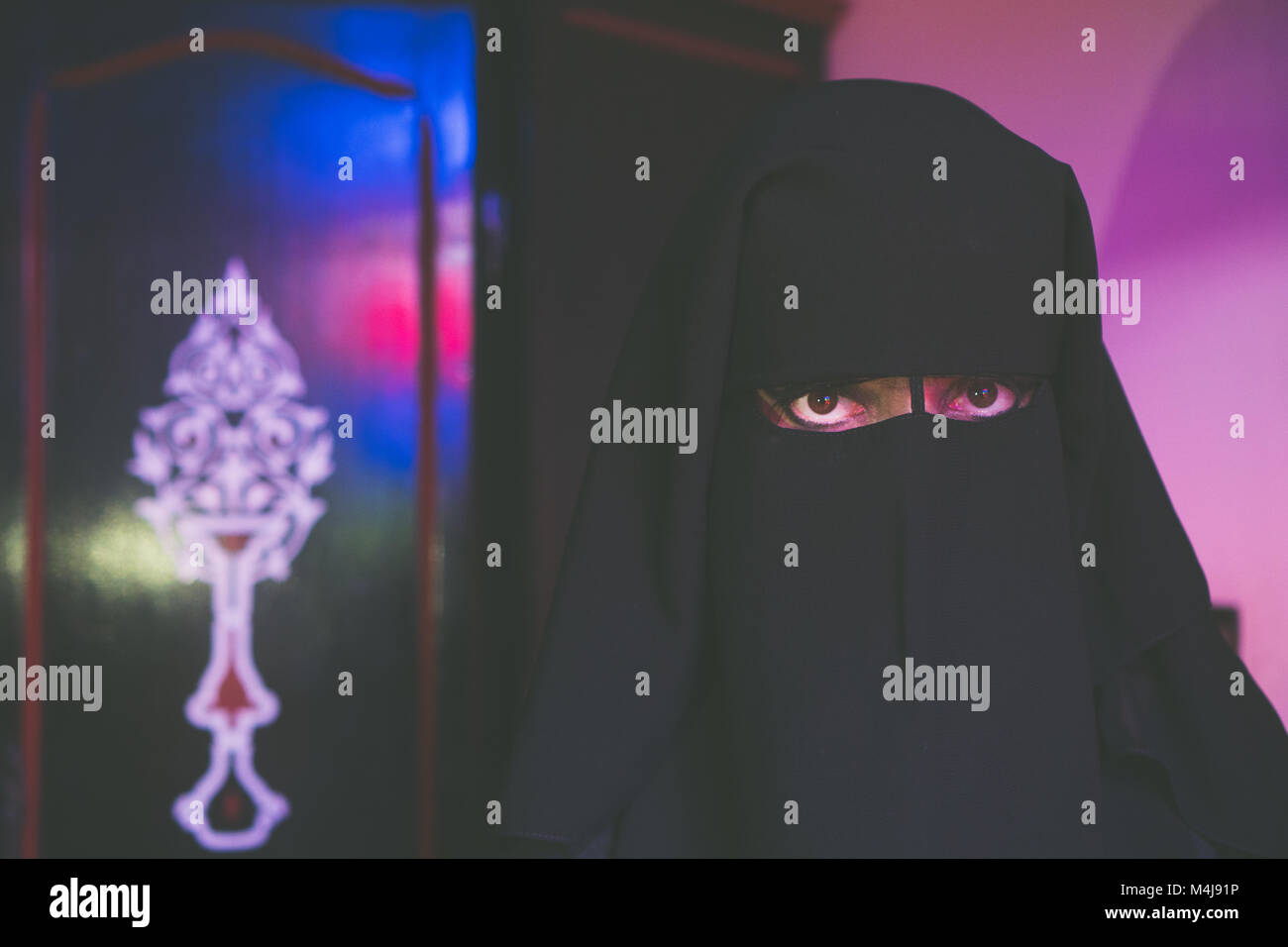 Arabische Frau in bescheidenen schwarze Kleidung mit Gesicht bedeckt mit schwarzem Niqab Stockfoto