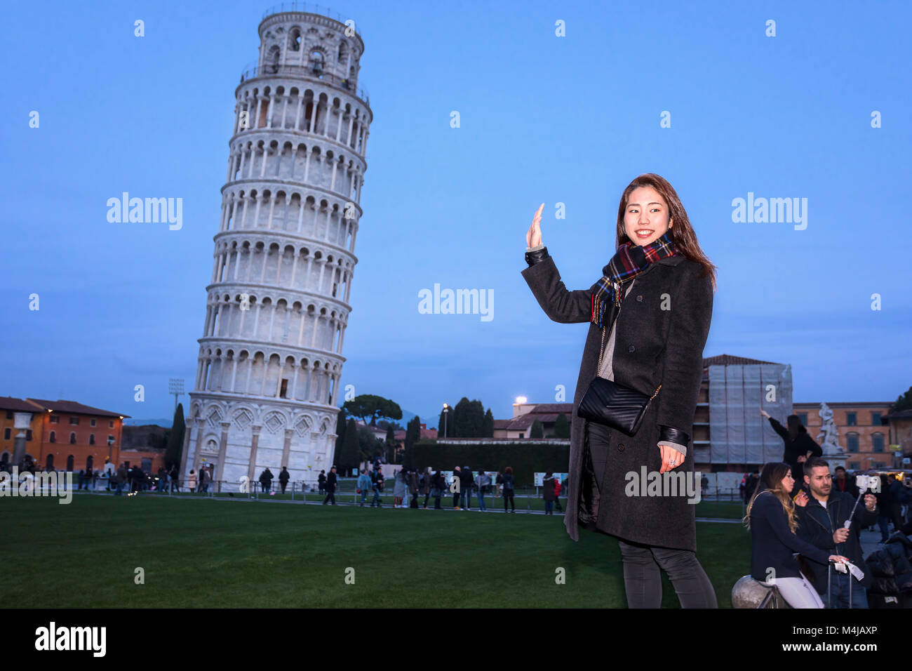 Pisa, Italien - 11. Februar 2018: Asiatische Girl posiert für ein Foto mit den berühmten Turm von Pisa im Hintergrund, in der Piazza dei Miracoli überfüllt mit t Stockfoto
