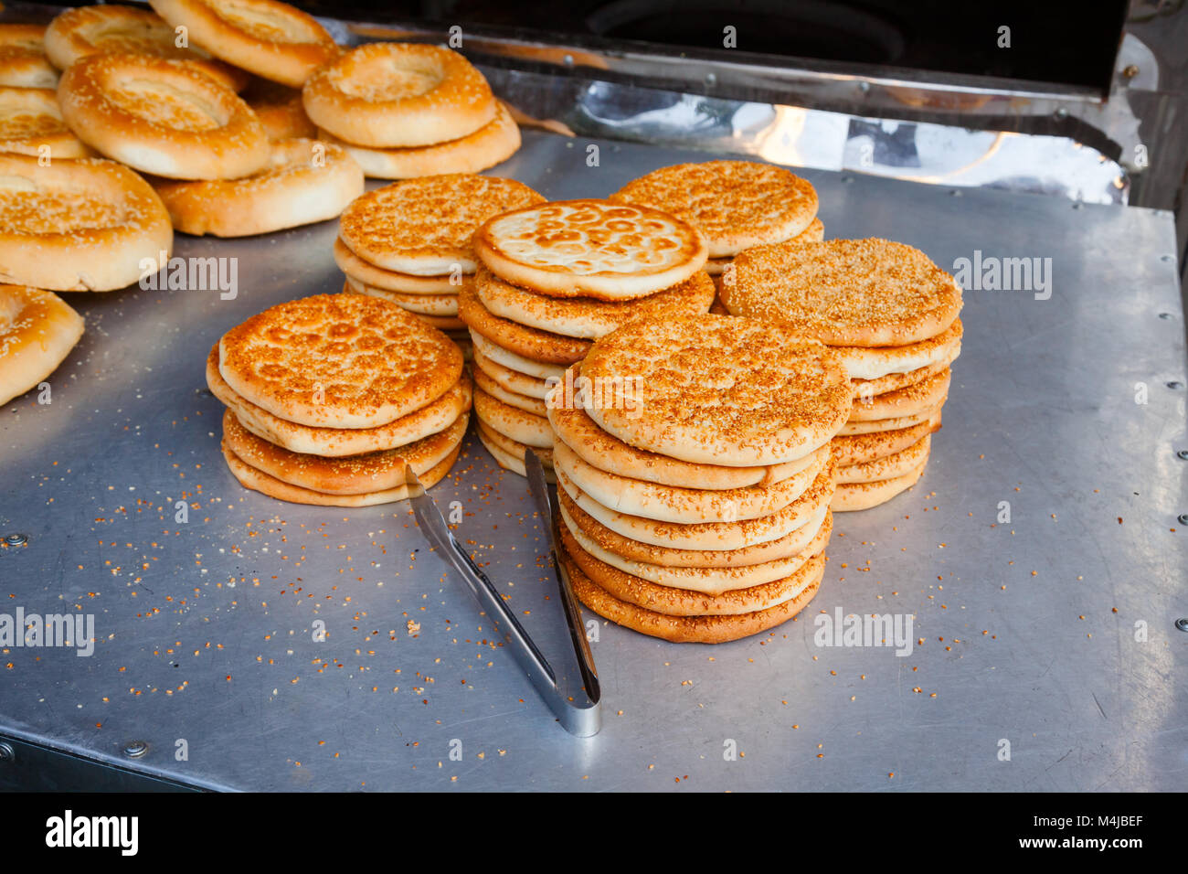 Frisch gebackene tandoor Brot Tohax (Toqach, Toghach) auf einer Straße zum Verkauf an Urumchi, Uigurischen Autonomen Region Xinjiang China Abschaltdruck Stockfoto