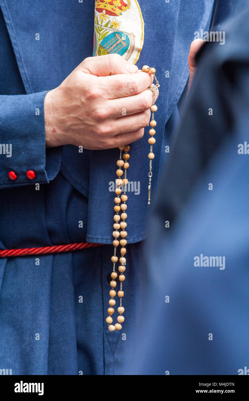 Detail der Hand des Pönitenten der Bruderschaft des "El Baratillo' mit einem Rosenkranz, zählen die Perlen beim Beten. Stockfoto