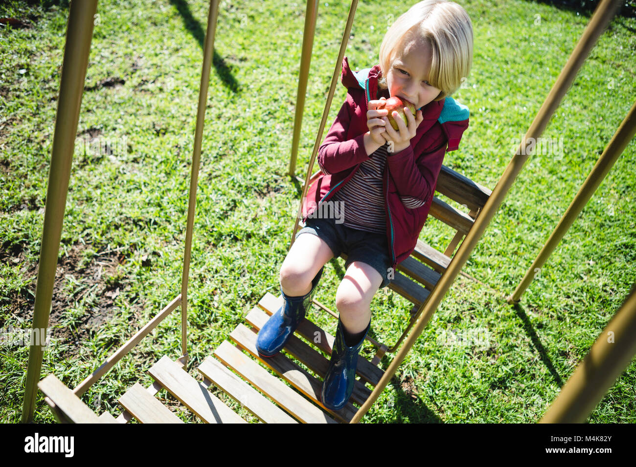 Junge entspannen in Schwingen an einem sonnigen Tag Stockfoto