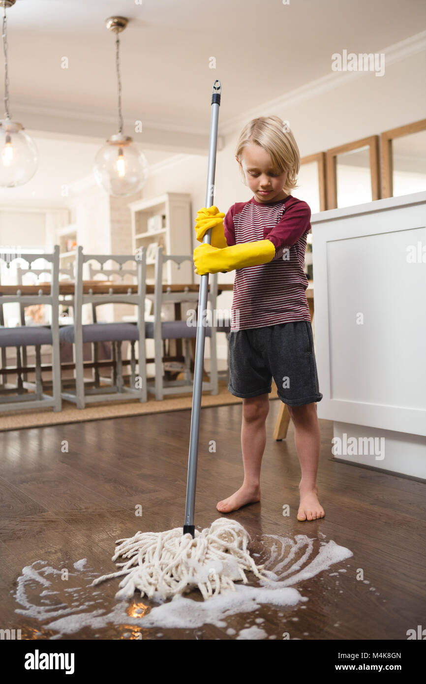 Junge waschen den Boden mit Mop Stockfoto