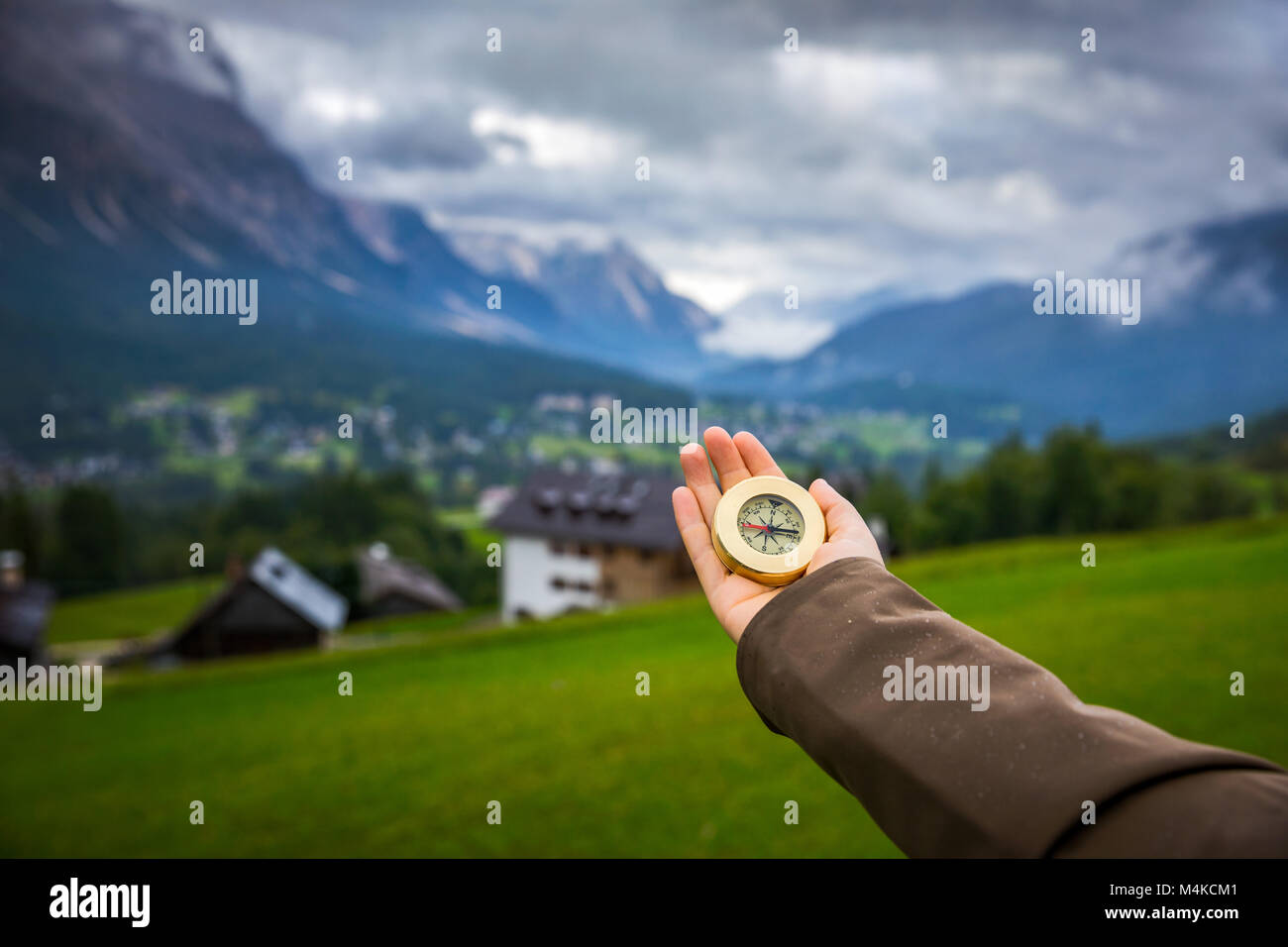 Frauen Hand mit einem Kompass in die Berge, Travel Concept. Hand mit Kompass am Mountain Road, Hintergrund der Berge im Sommer, Sicht. Stockfoto