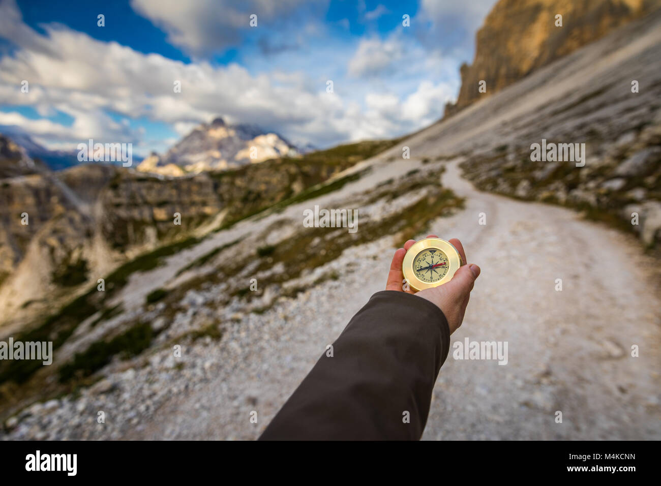 Frauen Hand mit einem Kompass in die Berge, Travel Concept. Hand mit Kompass am Mountain Road, Hintergrund der Berge im Sommer, Sicht. Stockfoto