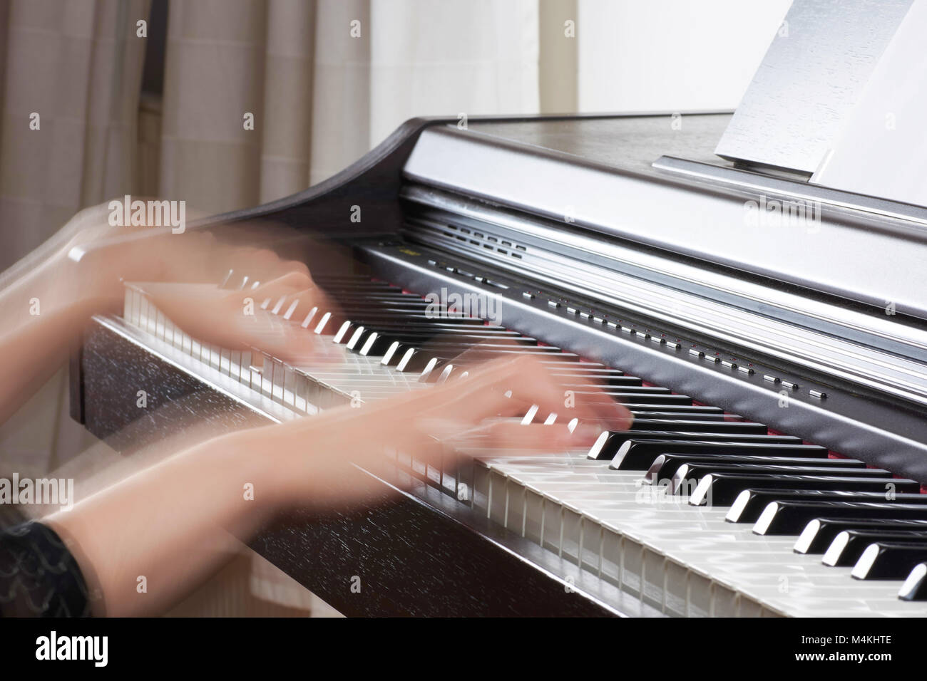 Holz- schwarz Piano mit Tastatur und weibliche Hände von Musikern Bewegung verschwommen, mit unscharfen Hintergrund Stockfoto