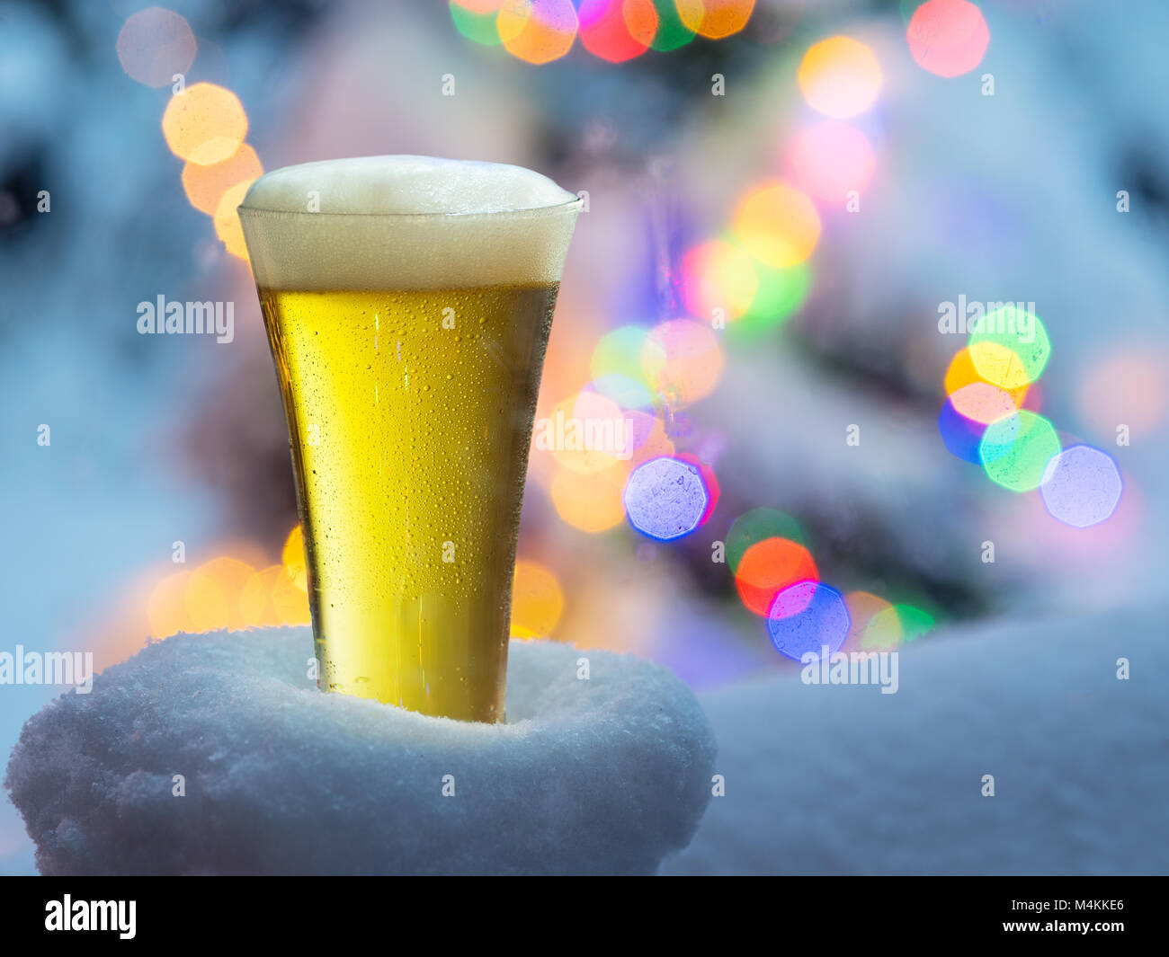 Glas Bier mit Magic Christmas lights im Hintergrund. Stockfoto